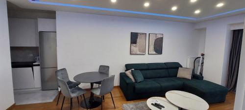 a living room with a green couch and a table at Extra Apartman Palata in Banja Luka