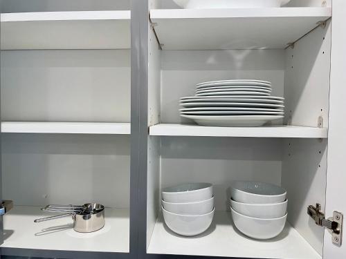 a cupboard filled with white plates and dishes at Elevator-Work Here-Gig WiFi-King Bed-Laundry in unit in Walnut Creek