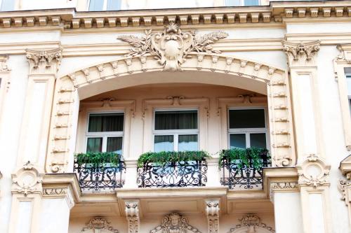 a building with a balcony with plants on it at Drei Kronen Hotel Wien City in Vienna