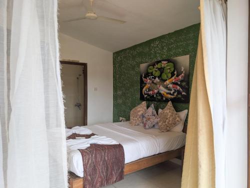 a bedroom with a bed with a painting on the wall at Villa Candolim in Candolim