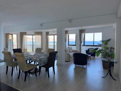 a dining room and living room with a table and chairs at Buenavista Las Canteras in Las Palmas de Gran Canaria