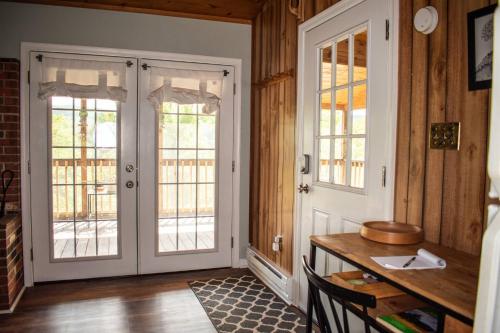 a room with a door and a desk with a table at Cozy Forest Escape with Porch and AC in Lost City