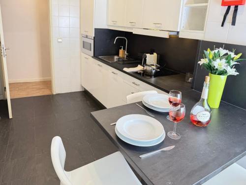 a kitchen with a table with plates and wine glasses at Ribeira Cinema Apartments in Porto