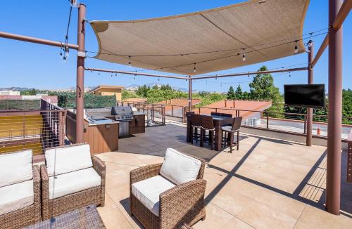 a patio with a table and chairs and a television at Bright Top Floor-Elevator-Walk Downtown-Laundry in Walnut Creek