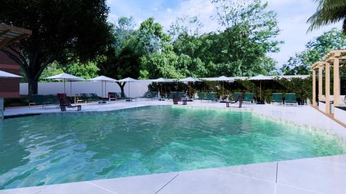 a large pool of water with chairs and umbrellas at Hotel Ilha do Marajó by Unna in Soure