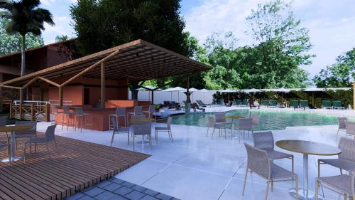a patio with tables and chairs next to a pool at Hotel Ilha do Marajó by Unna in Soure