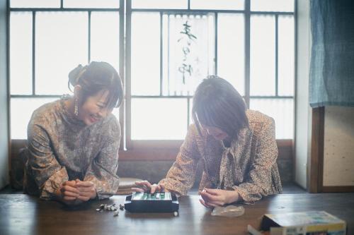 two women sitting at a table looking at a camera at Sokuan a 120 Year Old Art Filled Inn in Yui