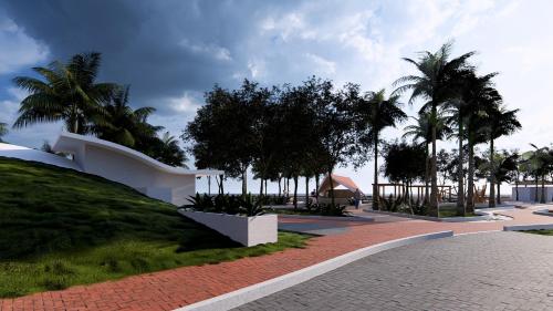 a white building with palm trees and a sidewalk at Hotel Ilha do Marajó by Unna in Soure