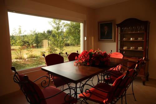 a dining room table with red chairs and a large window at ART HOUSE Kosmaj 2 in Sopot