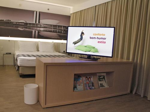 a tv on top of a room with a bed at ibis Styles Brasilia Aeroporto in Brasilia