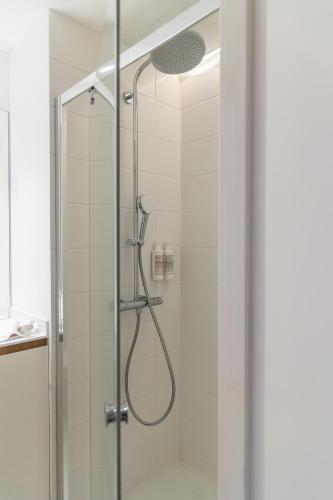 a shower with a glass door in a bathroom at Babel Community Hôtel Lille - Villeneuve d'Ascq in Villeneuve d'Ascq