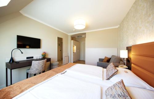 a hotel room with a bed and a living room at Drei Kronen Hotel Wien City in Vienna
