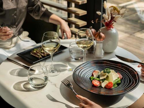 a table with a plate of food and wine glasses at Novotel Paris Coeur d'Orly Airport in Orly