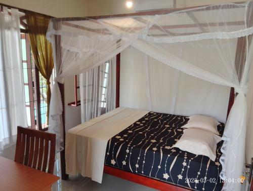 a bedroom with a bed with a canopy at Zen Heaven Villa Mirissa south Kamburugamuwa in Nikawatawana