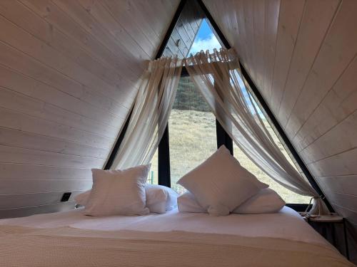 a bed with two pillows in a room with a window at Space Trip Hotel in Artavaz