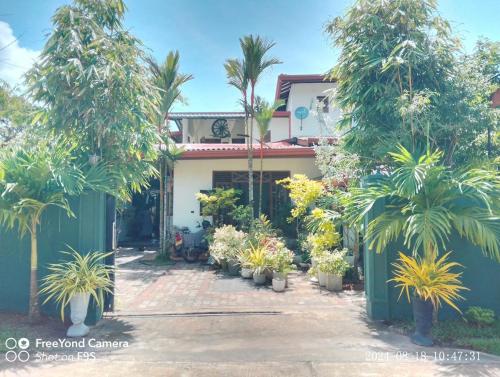 a house with palm trees in front of it at Zen Heaven Villa Mirissa south Kamburugamuwa in Nikawatawana