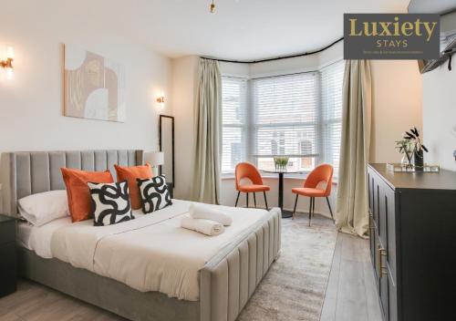 New! Stunning Studio City Centre Nr High St by Luxiety Stays في ساوثيند أون سي: غرفة نوم مع سرير مع وسائد برتقالية وسوداء