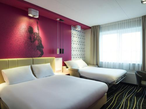 Una cama o camas en una habitación de ibis Styles Haarlem City