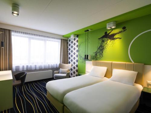 Una cama o camas en una habitación de ibis Styles Haarlem City