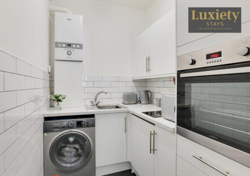 a white kitchen with a washer and a dishwasher at New! Stunning Studio City Centre Nr High Street in Southend-on-Sea
