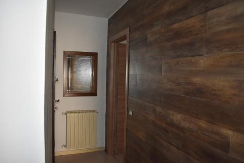 a hallway with a wooden wall and a door at Lago di Lugano - Casa Cecilia in Lavena Ponte Tresa