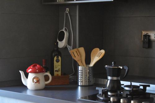 a kitchen counter with a stove with a bottle of wine at Lago di Lugano - Casa Cecilia in Lavena Ponte Tresa
