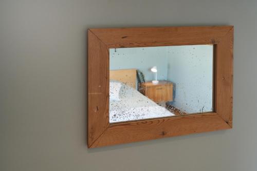a mirror hanging on a wall with a room at La Forge - Chambres d'hôtes en Ardenne in Wellin