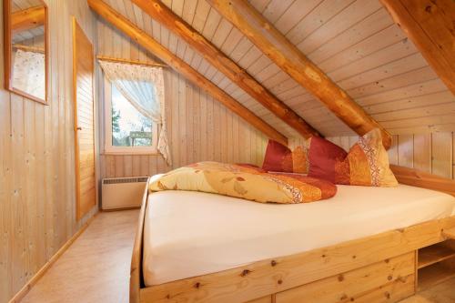 a bedroom with a bed in a wooden cabin at Märchenhafte Ferienhäuser in Zaulsdorf