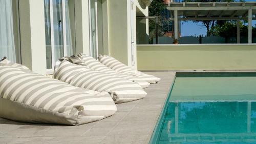 a row of pillows sitting next to a swimming pool at Hotel Europa in Misano Adriatico