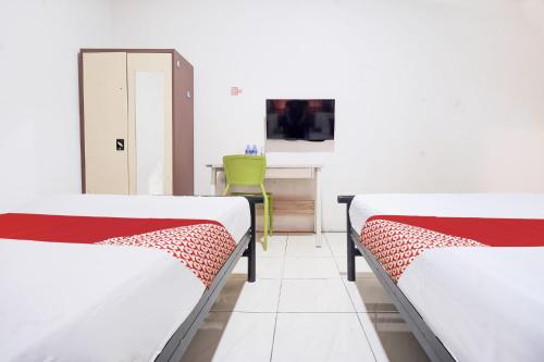 Ένα ή περισσότερα κρεβάτια σε δωμάτιο στο OYO 94774 Mulia House