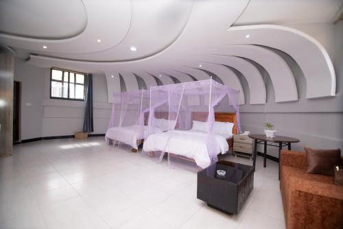 a bedroom with two beds and a ceiling at Jade Inn in Arusha