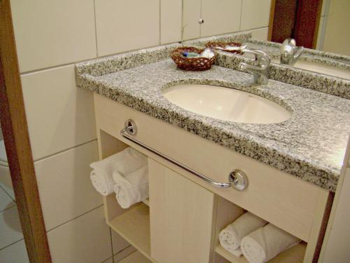 a bathroom sink with a granite counter top at Bay Park Hotel Resort in Brasília