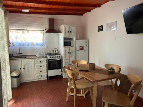 a kitchen with a wooden table and a kitchen with white appliances at Cabañas San Jorge N4 in Bella Vista