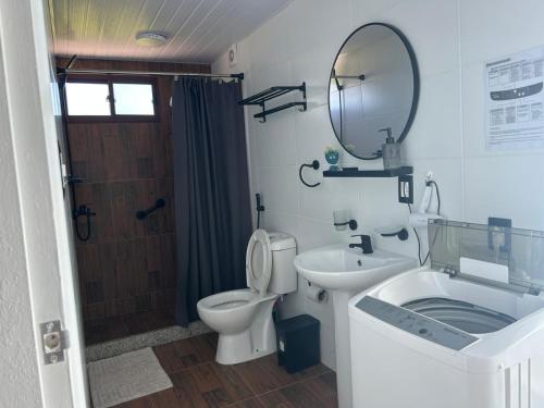 a bathroom with a toilet and a sink and a mirror at Cabañas San Jorge N4 in Bella Vista