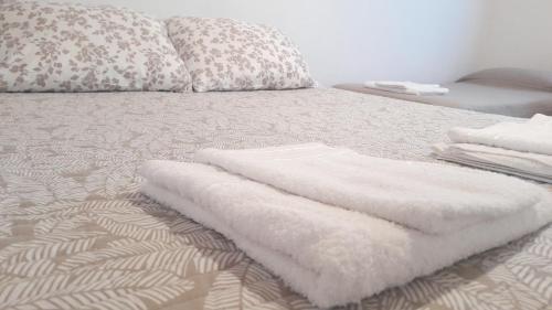 a pile of white towels sitting on top of a bed at Piedrabuena Yenua in Comandante Luis Piedra Buena