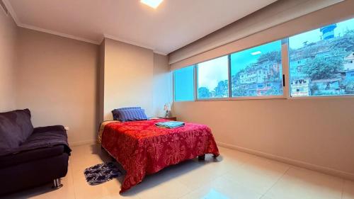 a bedroom with a bed and a couch and a window at River Front 1, 4 personas, 2 baños, agua caliente, wiffi, smartv, cocina in Guayaquil