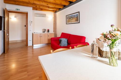 a kitchen and living room with a red couch at Agriturismo Al Tralcio in Valeggio sul Mincio
