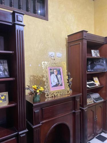 a room with a fireplace with a picture of a man at hotel san nicolas colonial in Barranquilla