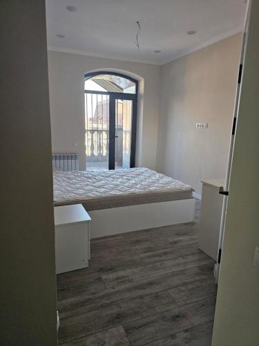una camera da letto con un letto e una porta aperta di Двухэтажная квартира на Элебаева a Bishkek