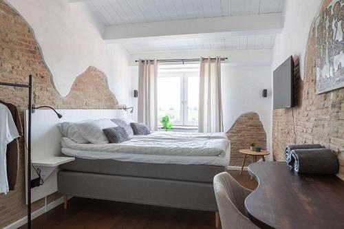 a bedroom with a bed and a brick wall at Charming Boutique B&B Hotel in Villalfonsina
