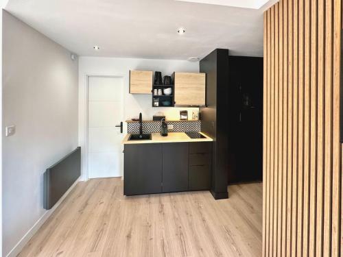 a kitchen with a black and white kitchen at T3 tout neuf 6 personnes proche centre ville in Luchon
