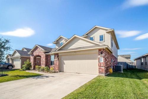 a brick house with a garage in a yard at Katy's five bedrooms home away from home! in Katy