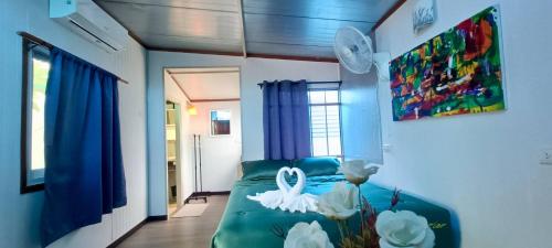 a living room with a green couch and white flowers at อู่ตะเภาโฮมสเตย์byต้นไทร in Ban Nong Sa
