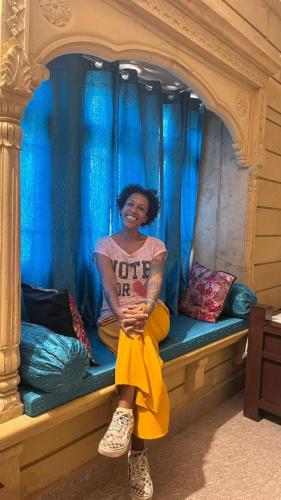 a woman sitting on a bench in a play house at Relax Inn Jaisalmer in Jaisalmer