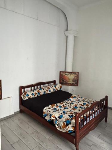 a bedroom with a bed with a wooden frame at Au cœur de Bejaia in Bejaïa