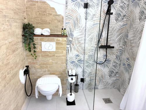 a bathroom with a shower and a toilet in it at Charming Boutique B&B Hotel in Villalfonsina