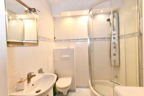 a bathroom with a sink and a toilet and a shower at Amber room in Sopot