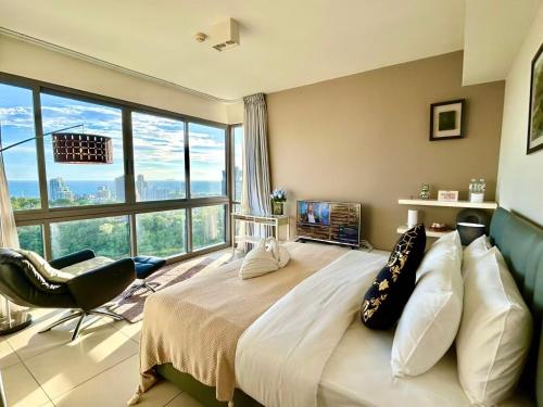 ein Schlafzimmer mit einem großen Bett mit einem großen Fenster in der Unterkunft South pattaya Unixx hotel in Pattaya South