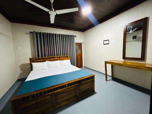 a bedroom with a large bed and a mirror at Santori By The Lake in Anuradhapura