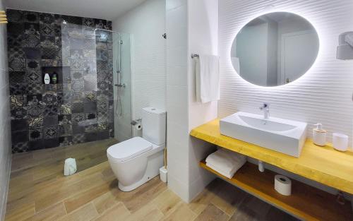 Un baño con lavabo, inodoro y espejo. en Casa Miradouro das Beatas, en Elvas